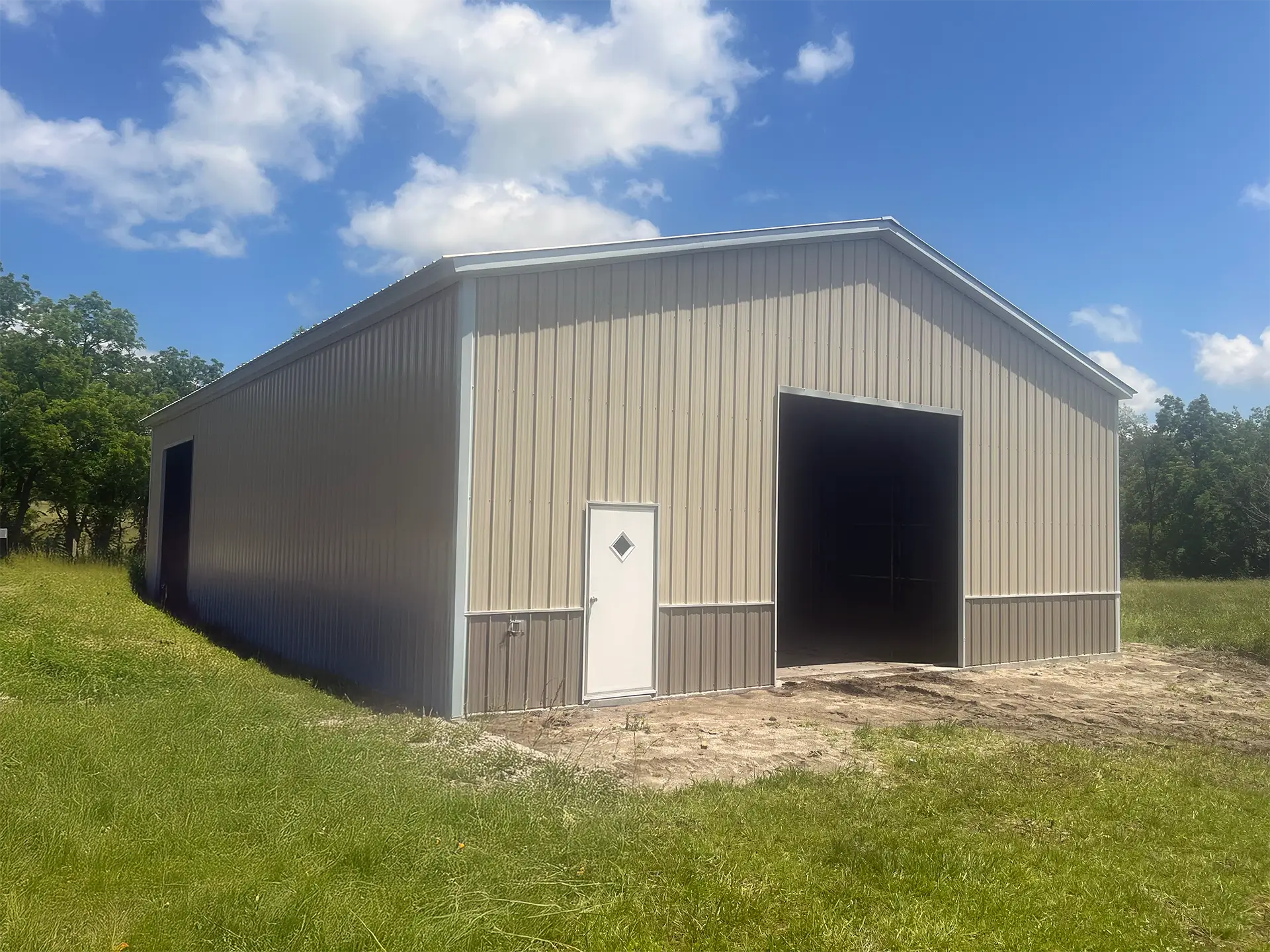 The Split Three Bay Workshop is a beige sandstone metal workshop with large doors and windows